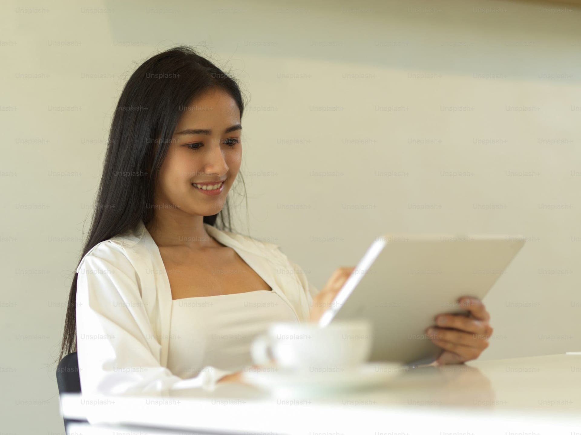 A young woman smiling at a tablet